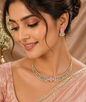 Vellorene blush pink crystal statement necklace set with matching earrings on soft satin background